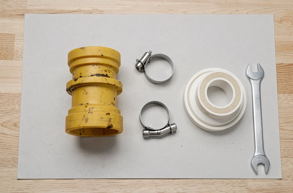 Comparaison entre un ancien raccord d'évacuation de lave-vaisselle usagé et un nouveau kit de remplacement