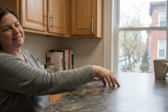 Femme souriante dans une cuisine moderne avec plan de travail en laminate