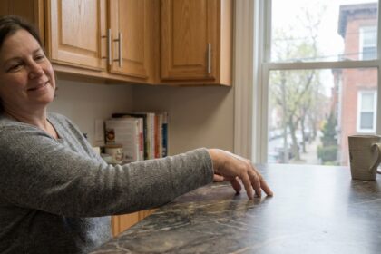 Femme souriante dans une cuisine moderne avec plan de travail en laminate